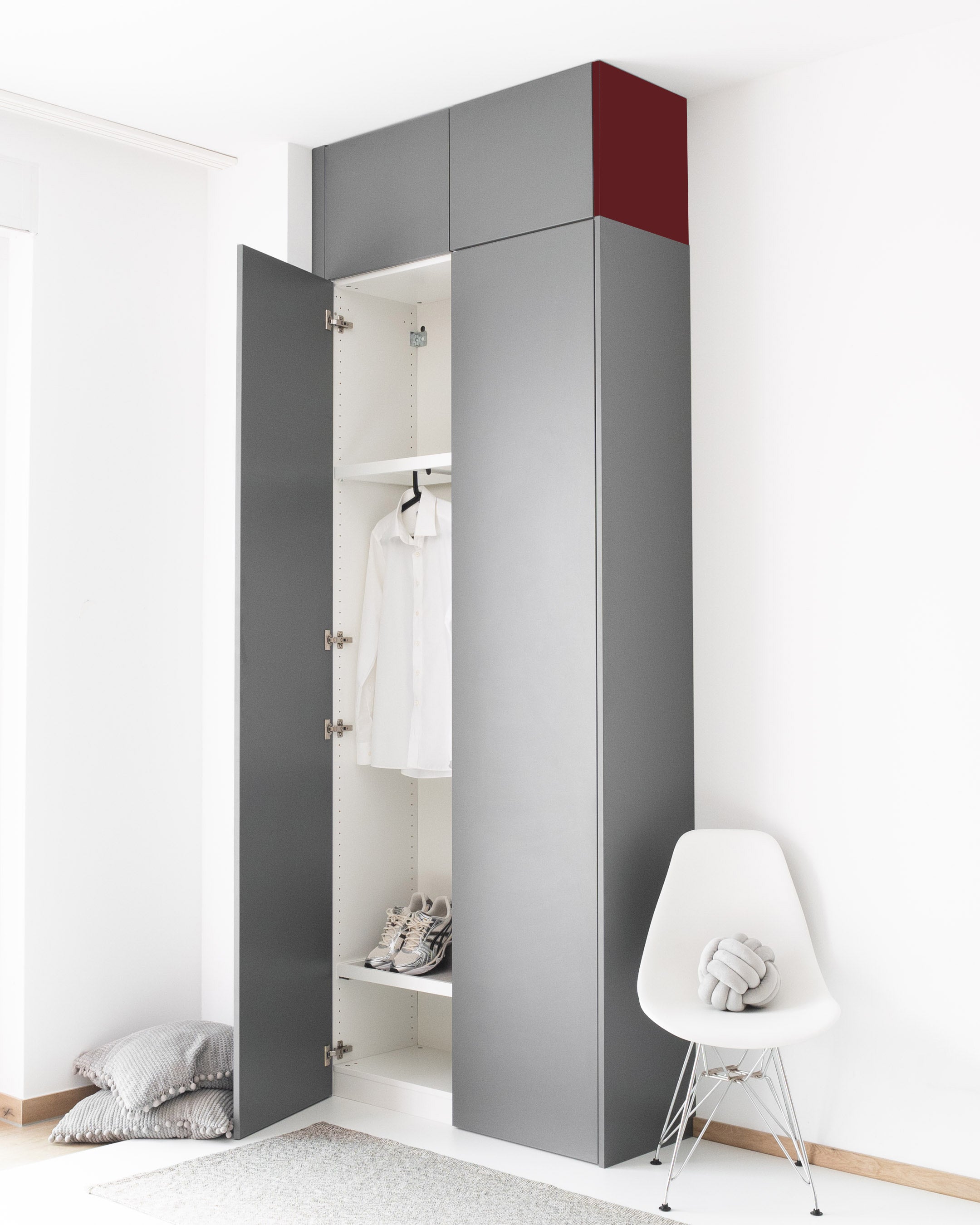 Graue PAX Aufsatzschrank-Außenseite mit rotem Akzent für eine bündige Schrankoptik.