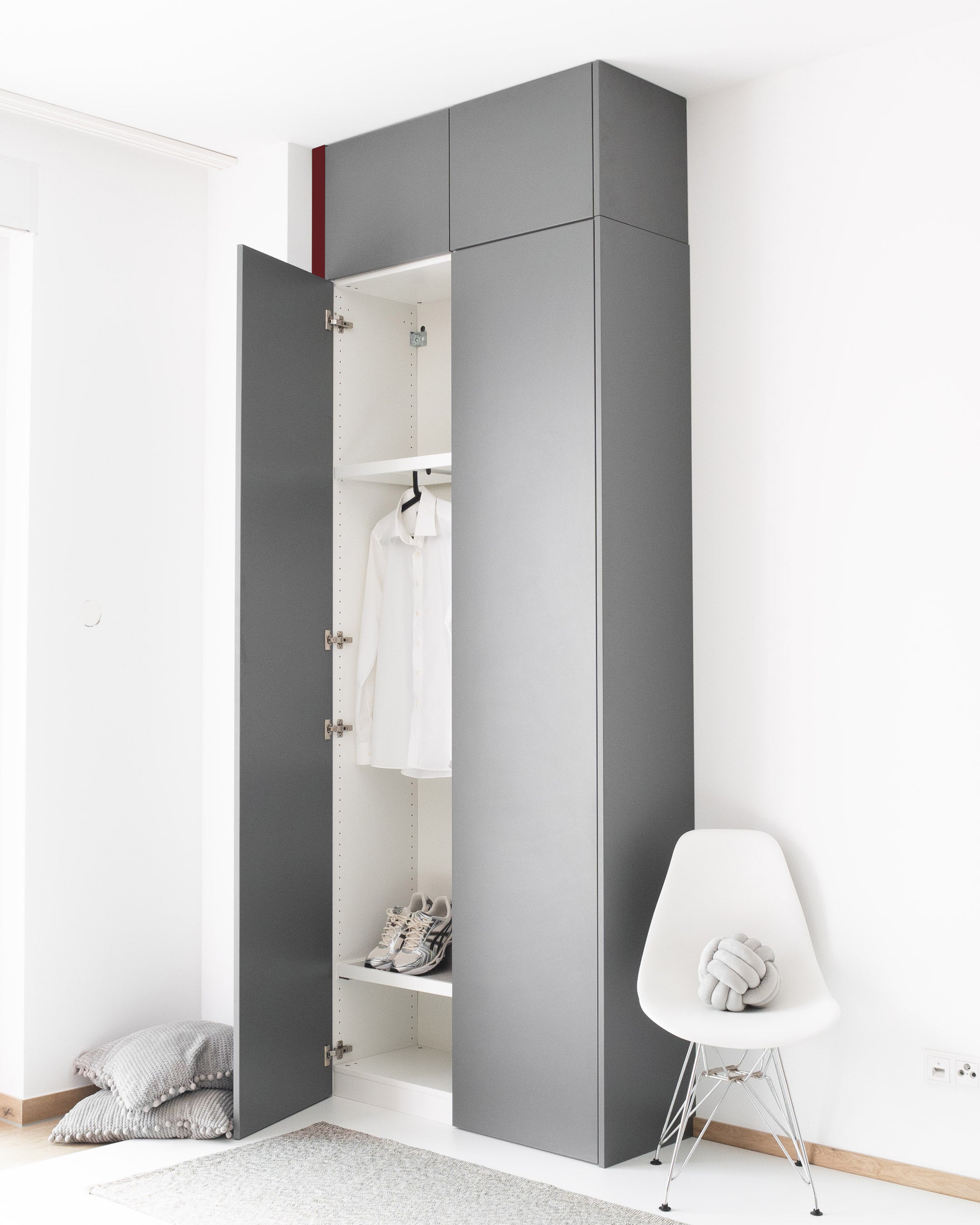 Eine graue Wandblende schließt den Spalt zwischen dem PAX Schrank und der weißen Wand.