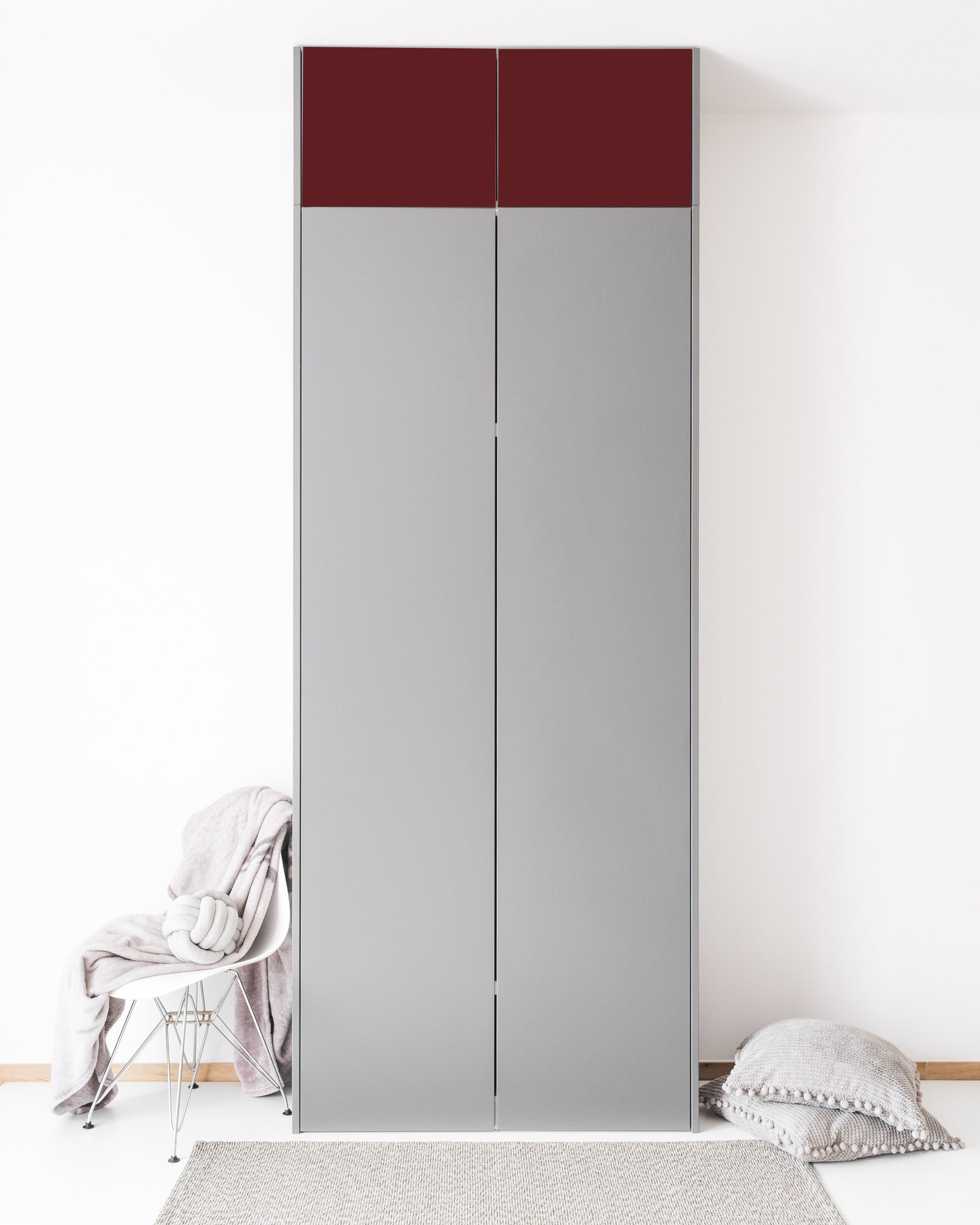 Graue PAX Aufsatzschranktüren mit dunkelroten Akzenten in einem minimalistischen Raum.