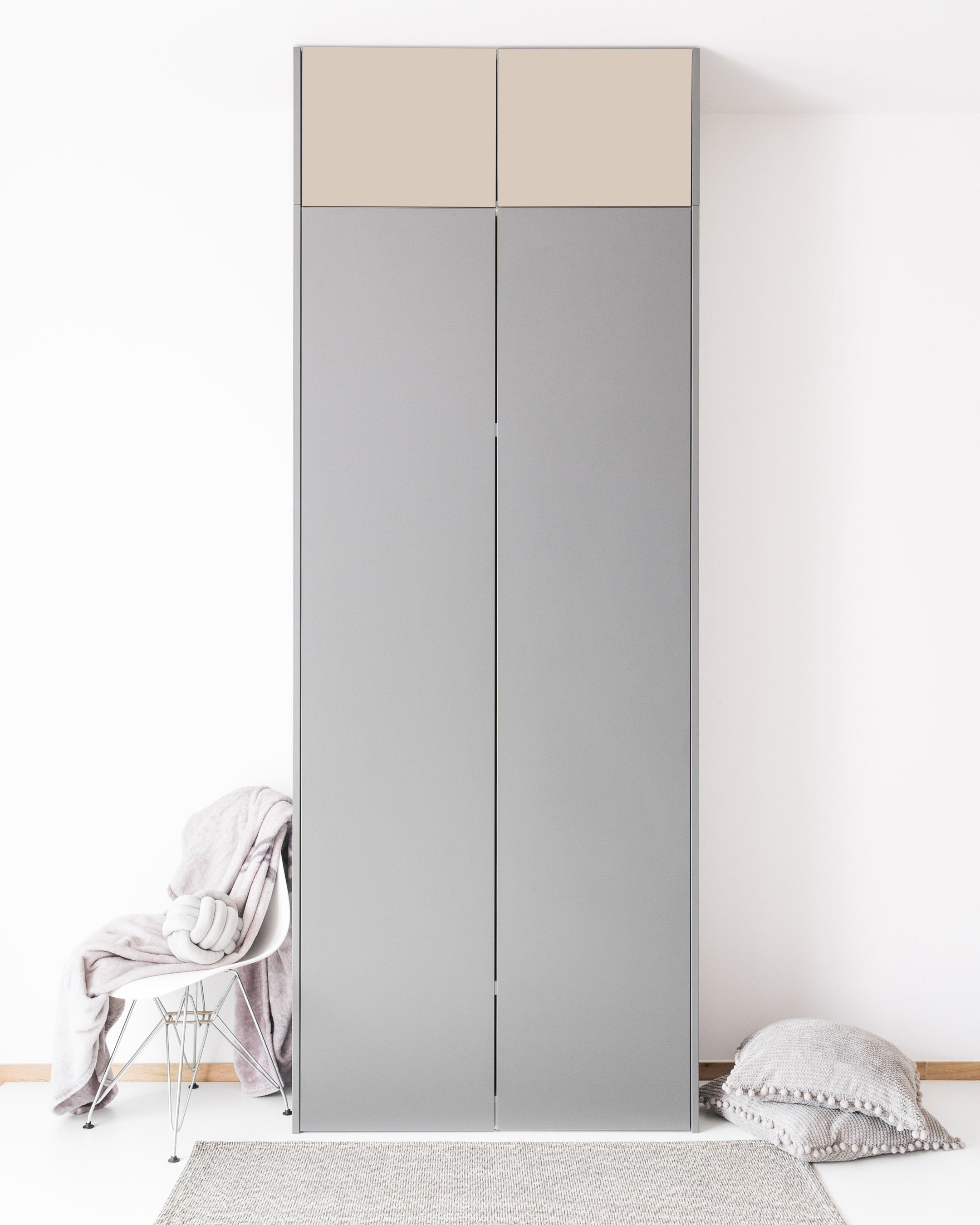 Graue Schranktüren mit beigen Aufsatzfronten in einer minimalistischen Raumgestaltung.
