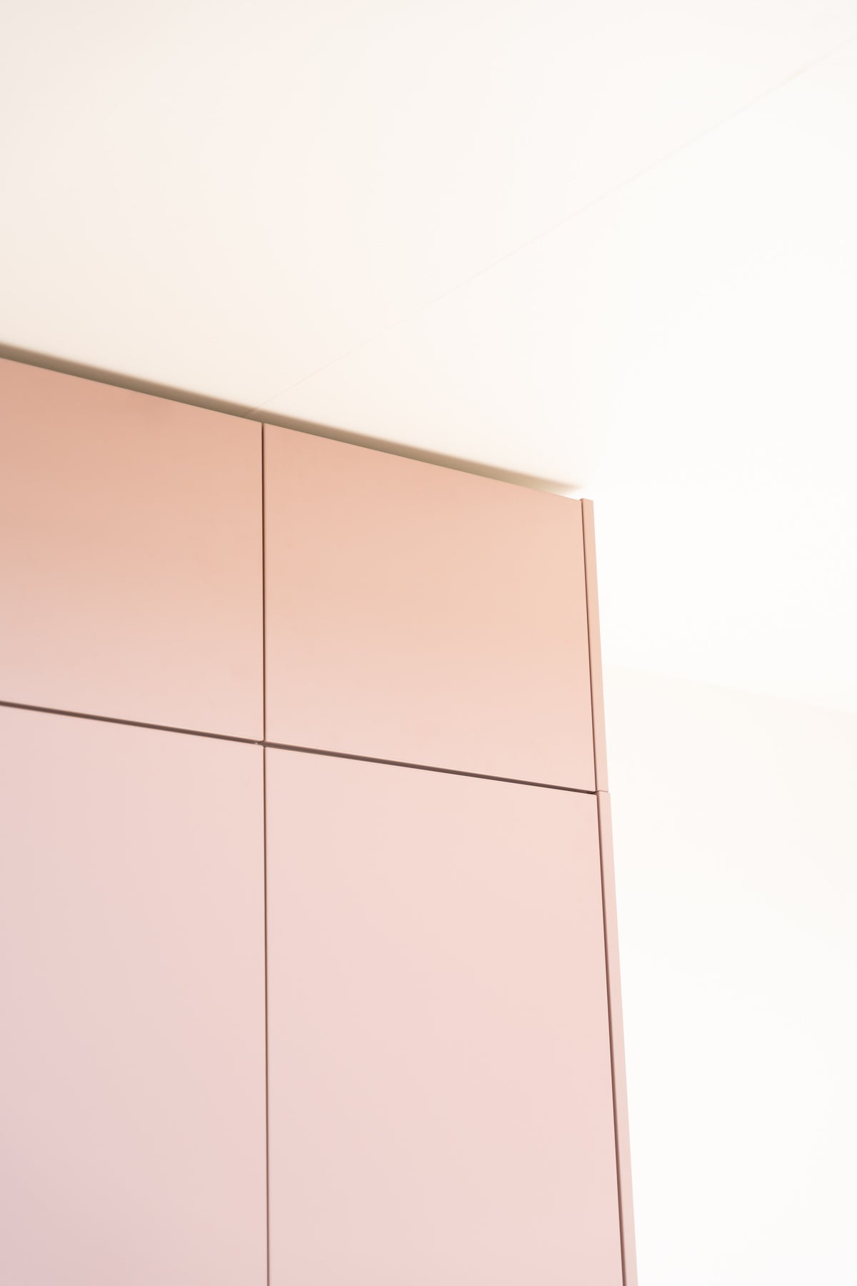 Ein rosafarbener Aufsatzschrank-Korpus für das IKEA PAX System vor einer weißen Wand.