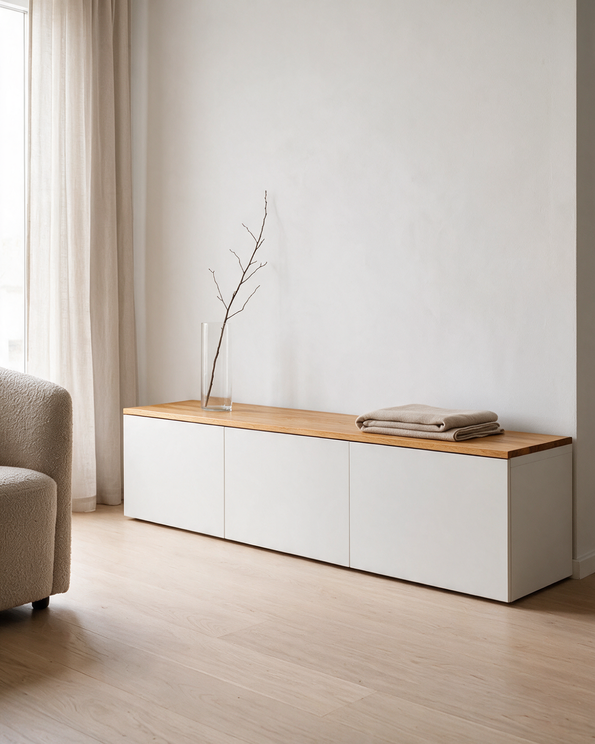 Massivholz-Deckplatte aus Eiche in Amber Oak (warmer Honigton) auf einem flachen weißen IKEA BESTÅ Sideboard mit drei Türen in einem hellen Wohnraum