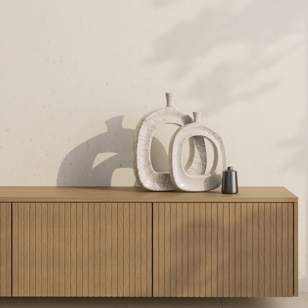 Ein Besta Sideboard mit vertikal gerillten Holzfronten und zwei dekorativen, hellen Vasen darauf.