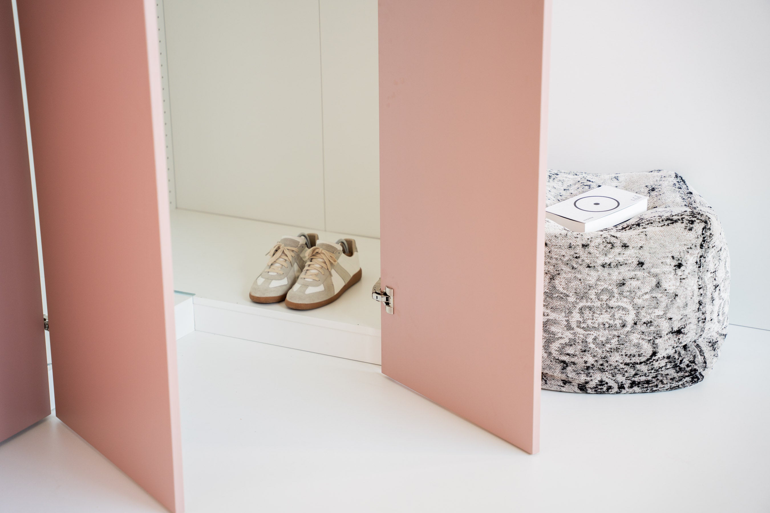 Ein Paar beigefarbene Sneaker steht in einem Schrank mit montiertem 155-Grad-Eckscharnier.