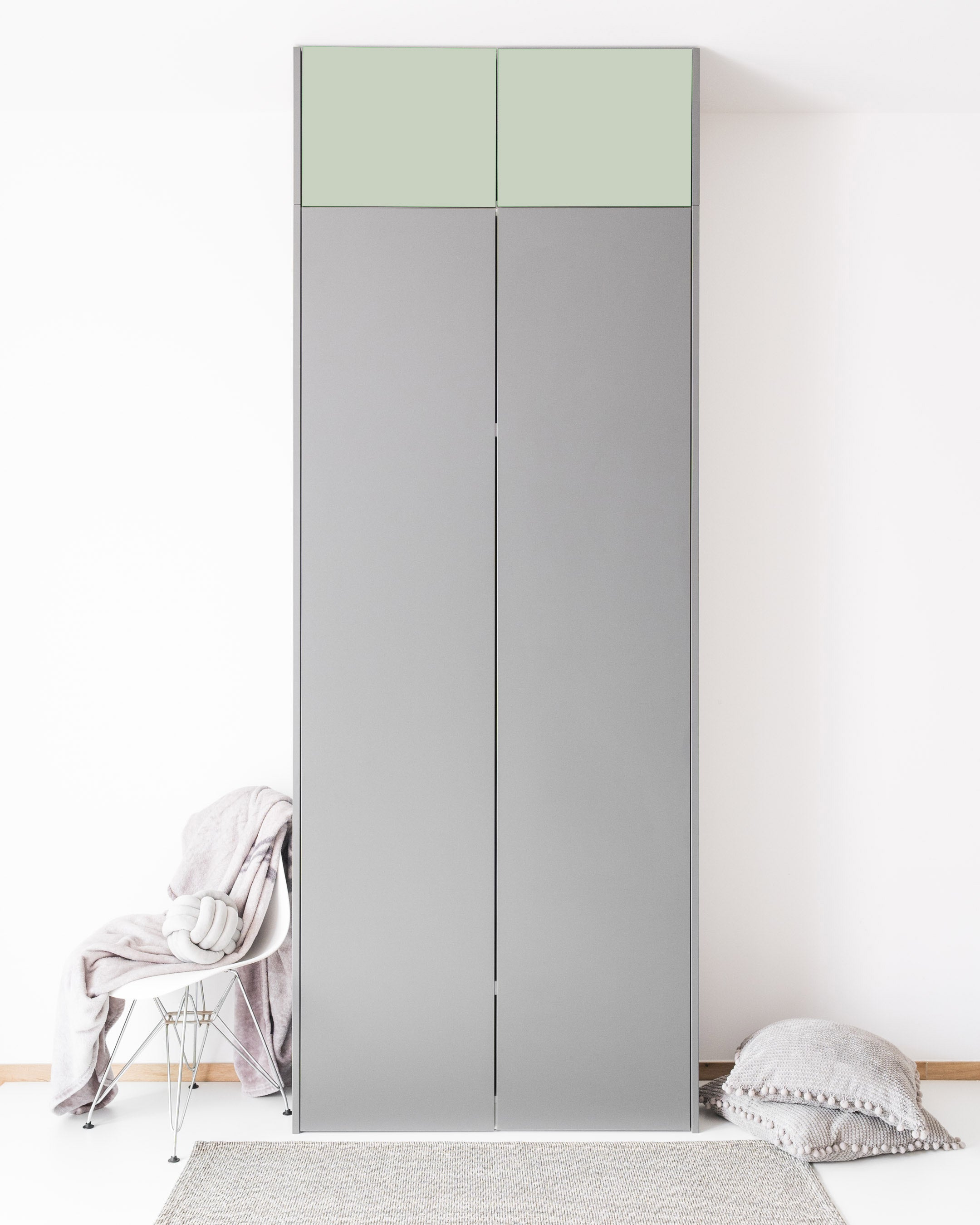 Zwei hellgrüne Aufsatzschranktüren in der Farbe Aurora Pure auf einem grauen Schrank.