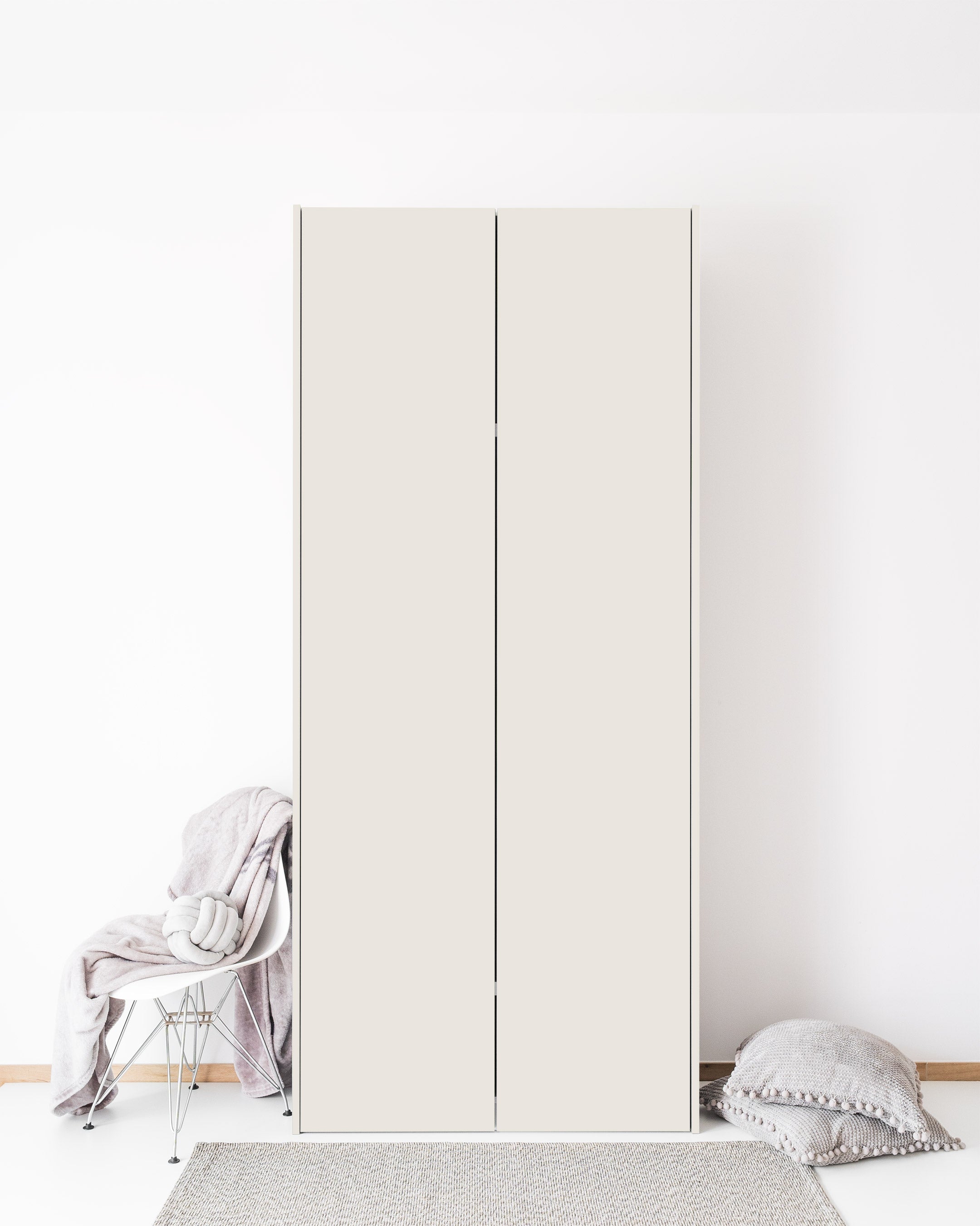 A tall, minimalist wardrobe in a matte dune finish stands against a plain white wall.
