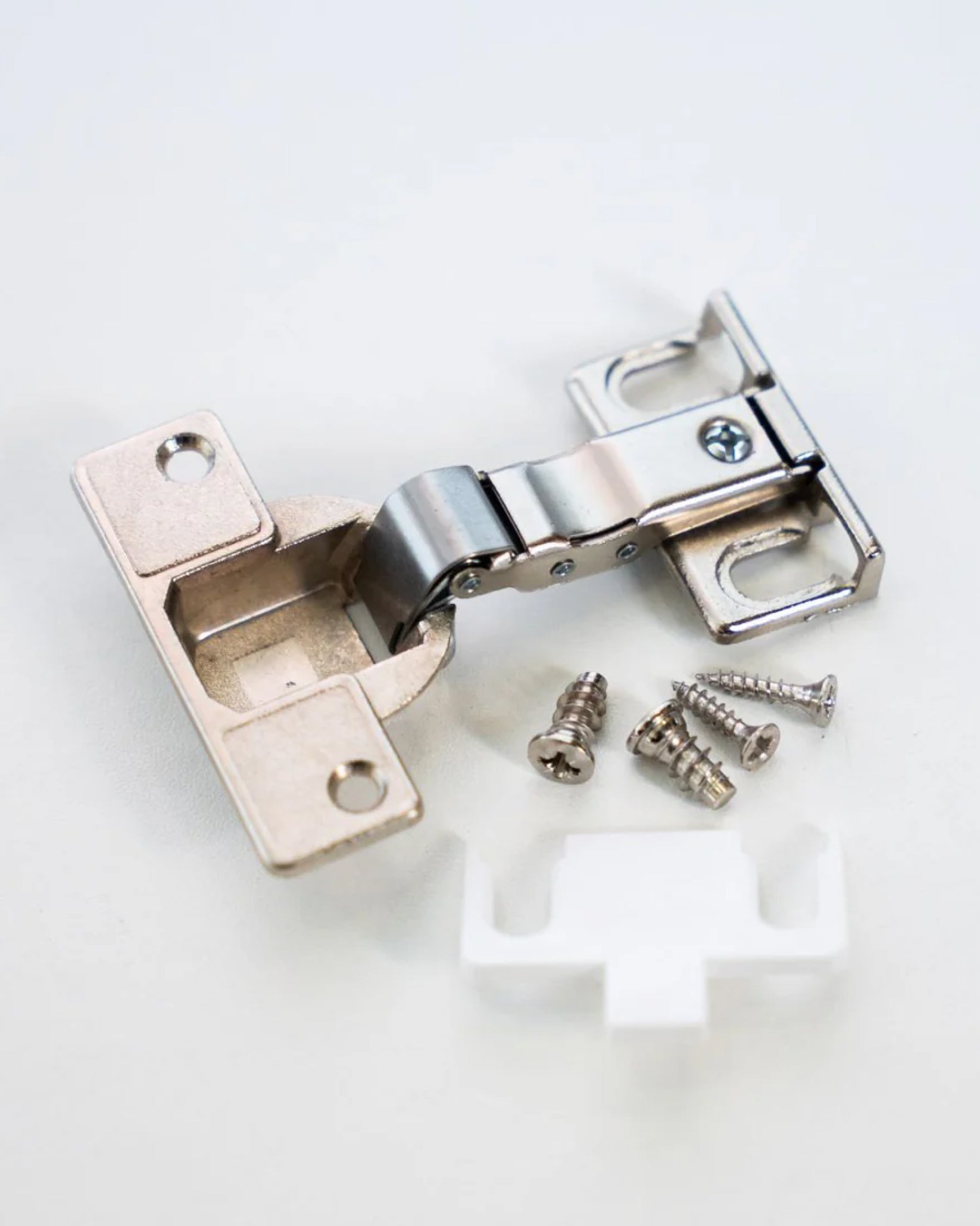Ein Spezialscharnier für IKEA PAX Schränke inklusive Schrauben und einer weißen Kunststoffabdeckung.